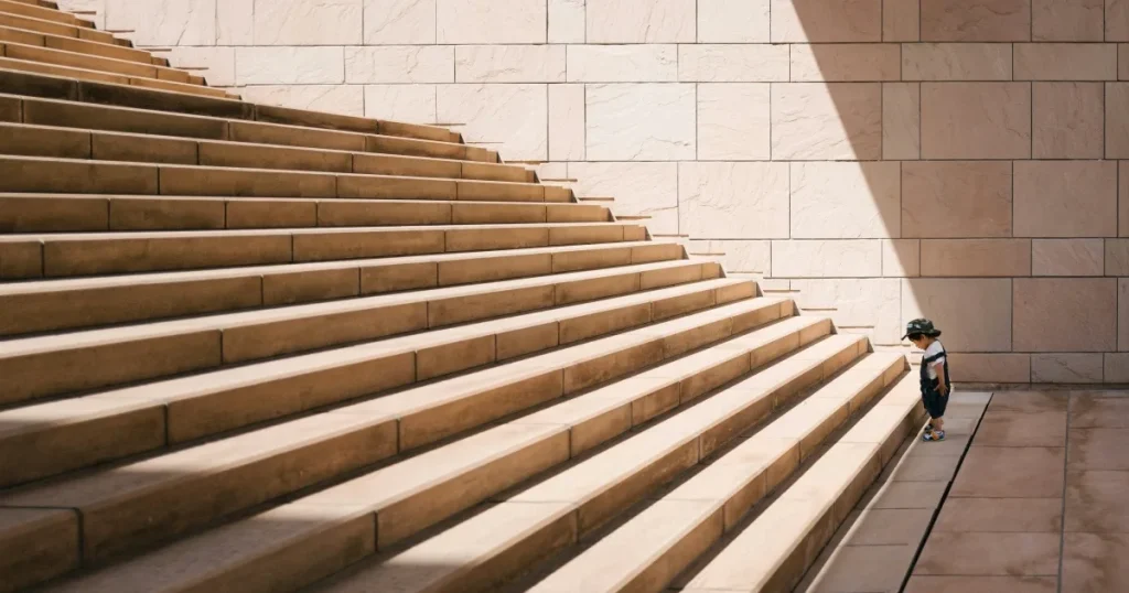 人生の勇気ある一歩を書いた内容を、小さい子供が長く大きな階段を登ろうとしている写真で表現