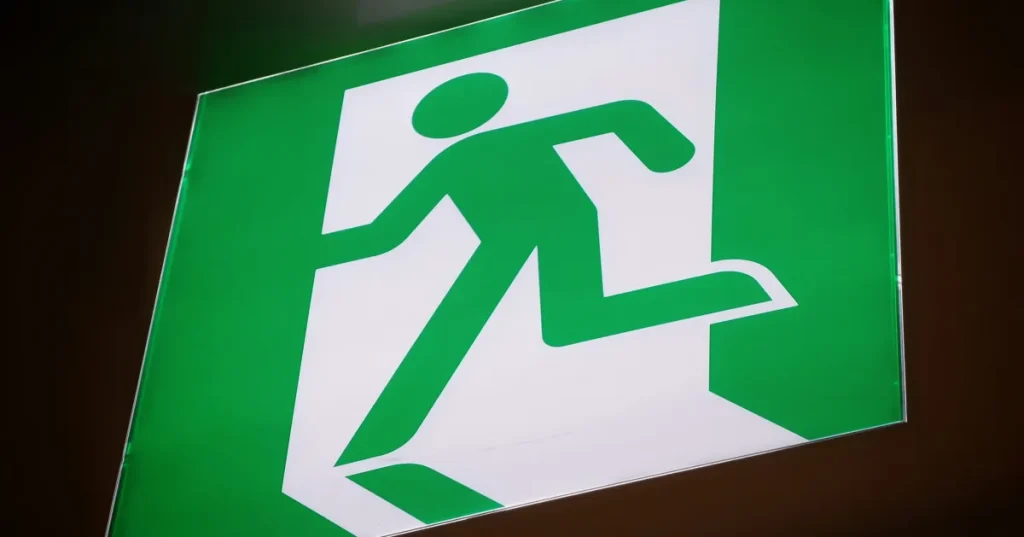 A sign depicting someone escaping with an emergency exit symbol.