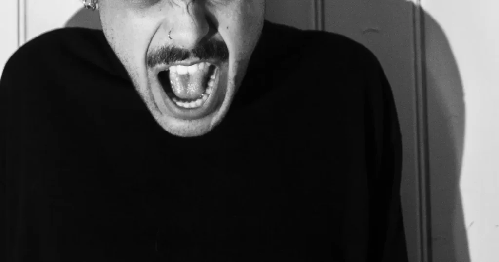 上司からの言葉によるパワハラを、男性が叫んでいる写真で表現