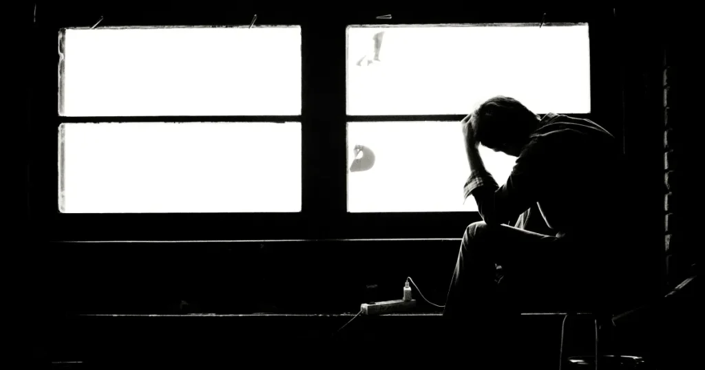 挫折をした内容を書いている文章に対して、暗い部屋の中頭を抱えている男性の写真をイメージ画像として使用